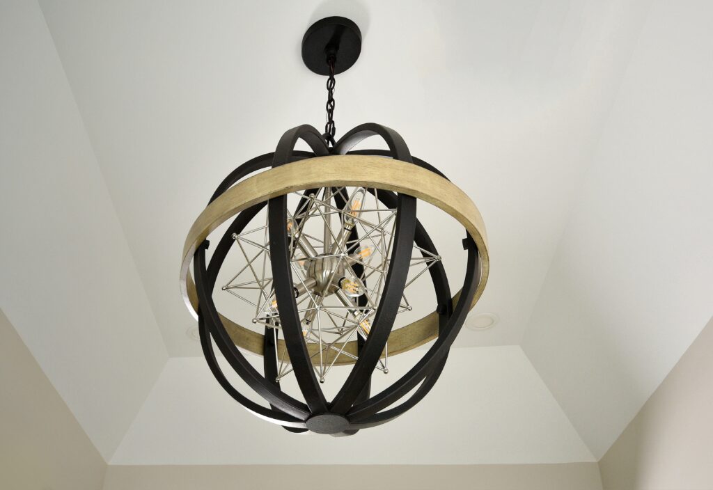 The gorgeous geometric star pendant in brushed nickel surrounded by a distressed textured bronze and washed wood orb.
